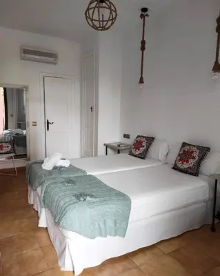 a large white bed in a white room at Hotel Pozo Rey by Youroom in Chipiona