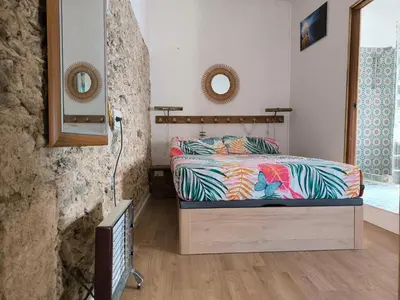 a bedroom with a bed with colorful sheets and a mirror at Chiclanero Loft in Chiclana de la Frontera