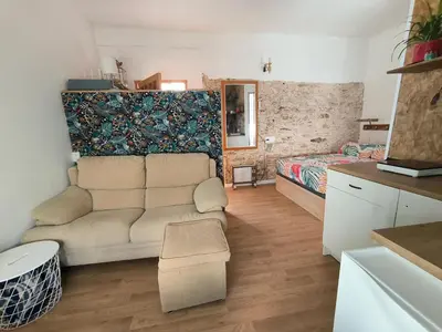 a living room with a couch and a bed at Chiclanero Loft in Chiclana de la Frontera