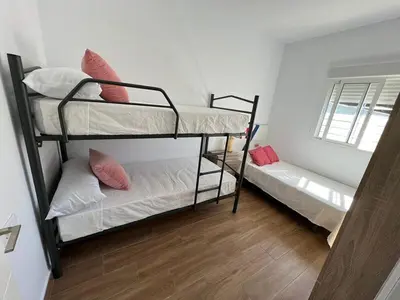 a room with two bunk beds and a window at ChiclanaVillage in Chiclana de la Frontera