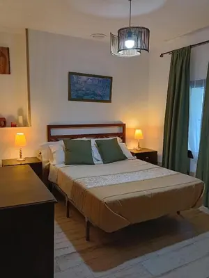 a bedroom with two beds and a chandelier at Vivienda Rural El Piketa in Algar