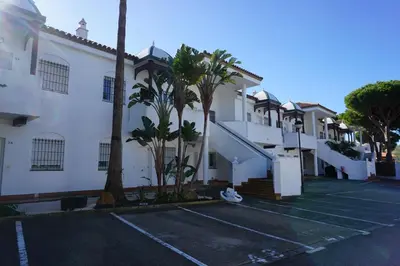 a parking lot in front of a building at Apartamento Chiclana playa in Poblado de Sancti Petri