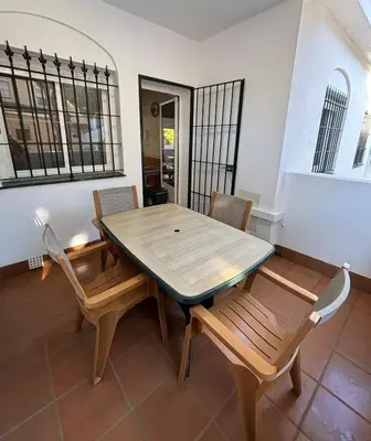 a dining room with a wooden table and chairs at Apartamento Chiclana playa in Poblado de Sancti Petri