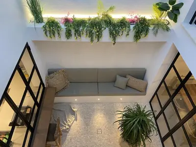 a room with a couch and plants on the wall at Casa junto al mar con piscina 45 in Conil de la Frontera