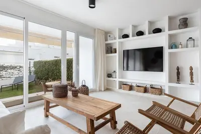 a living room with a table and a tv at Casa junto al mar con piscina 45 in Conil de la Frontera