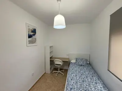 a small bedroom with a bed and a desk at Apartment Las Mareas in Puerto Real
