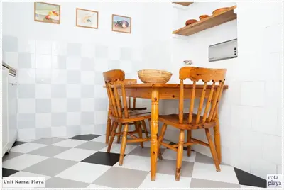a dining room table and chairs with a checkered floor at Family Friendly 2BDR Unit in Rota - Playa in Rota