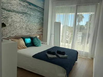 a bedroom with a large bed with towels on it at Nuevo bajo con gran jardín en primera línea playa in Chipiona