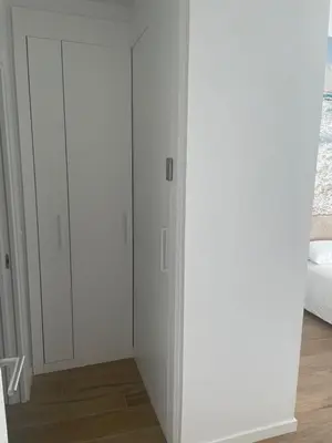 a white closet with white cabinets in a bedroom at Nuevo bajo con gran jardín en primera línea playa in Chipiona