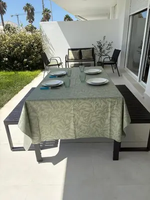 a table with plates and napkins on a patio at Nuevo bajo con gran jardín en primera línea playa in Chipiona