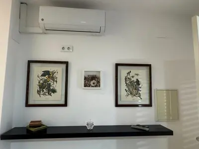 a white wall with two framed pictures on it at Austria 03 in Lebrija