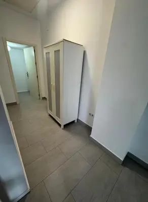 an empty room with a white refrigerator and a tile floor at Austria 03 in Lebrija