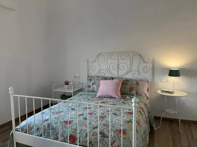 a bedroom with a white bed with a pink pillow at Los Granainos in El Guijo