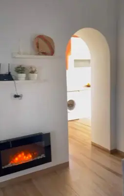 a living room with a fireplace and an archway at Los Granainos in El Guijo