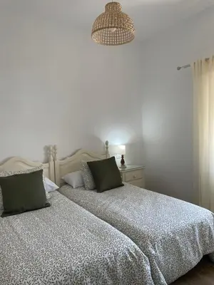 a bedroom with a bed and a chandelier at Los Granainos in El Guijo