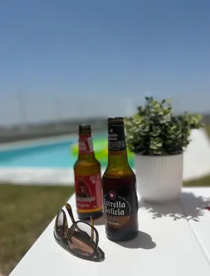 two bottles of beer and a pair of glasses on a table at Los Granainos in El Guijo