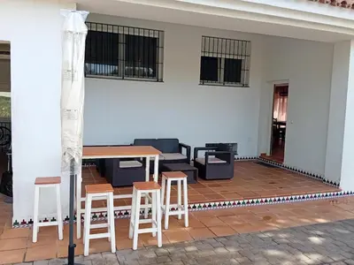 a living room with a table and chairs and a couch at Villa Playa La Barrosa in Novo Sancti Petri