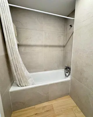 a bathroom with a bath tub with a shower curtain at Penthouse duplex with jacuzzi, 5 min to beach in Chipiona