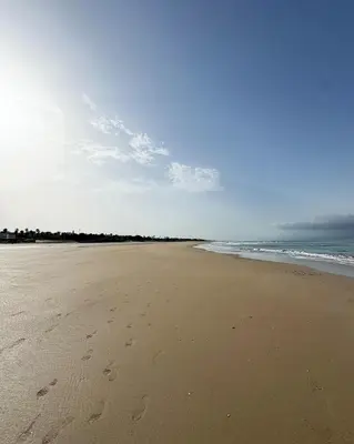 a beach with footprints in the sand and the ocean at Penthouse duplex with jacuzzi, 5 min to beach in Chipiona
