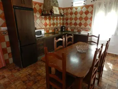 a kitchen with a wooden table and a dining room at Casas Elena-Conil in Conil de la Frontera