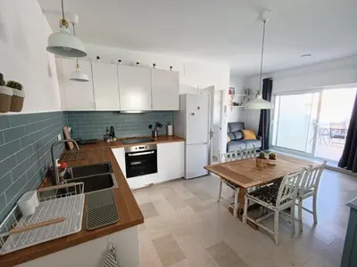 a kitchen with a table and a dining room at Ático recién reformado en el centro de Sanlúcar - LOVE SANLUCAR in Sanlúcar de Barrameda