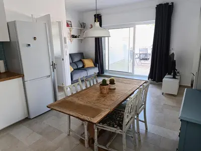 a kitchen and dining room with a wooden table and chairs at Ático recién reformado en el centro de Sanlúcar - LOVE SANLUCAR in Sanlúcar de Barrameda