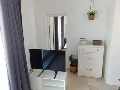 a living room with a tv and a white dresser at Ático recién reformado en el centro de Sanlúcar - LOVE SANLUCAR in Sanlúcar de Barrameda
