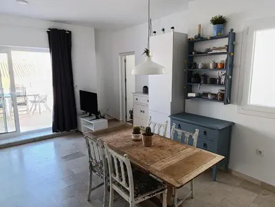 a dining room with a wooden table and a blue cabinet at Ático recién reformado en el centro de Sanlúcar - LOVE SANLUCAR in Sanlúcar de Barrameda