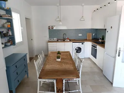 a kitchen with a wooden table and chairs at Ático recién reformado en el centro de Sanlúcar - LOVE SANLUCAR in Sanlúcar de Barrameda