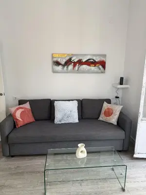 a living room with a couch and a glass table at GATU Prioral in El Puerto de Santa María