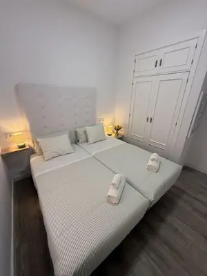 a bedroom with two beds with towels on them at GATU Prioral in El Puerto de Santa María