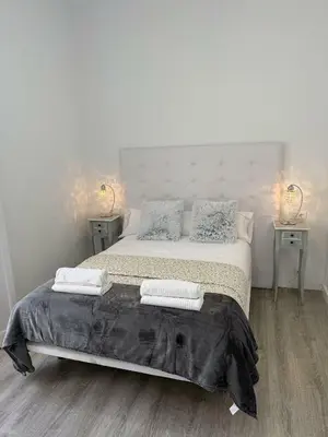 a bedroom with a large bed with two night stands at GATU Prioral in El Puerto de Santa María