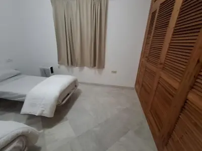 a bedroom with a white bed and a window at Hacienda La Caridad in El Puerto de Santa María