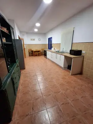 a large room with a kitchen with a tile floor at Hacienda La Caridad in El Puerto de Santa María