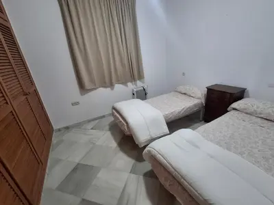 a room with two beds and a dresser in it at Hacienda La Caridad in El Puerto de Santa María