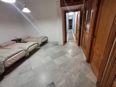a room with two beds and a hallway at Hacienda La Caridad in El Puerto de Santa María