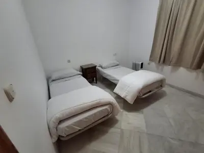 two beds in a room with white walls at Hacienda La Caridad in El Puerto de Santa María