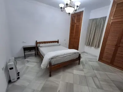 a bedroom with a bed and a chandelier at Hacienda La Caridad in El Puerto de Santa María