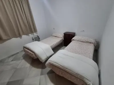 a room with two beds with white blankets at Hacienda La Caridad in El Puerto de Santa María