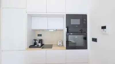 a white kitchen with white cabinets and appliances at Casa Chica 1 Sanlúcar de Barrameda. by Ruralidays in Sanlúcar de Barrameda