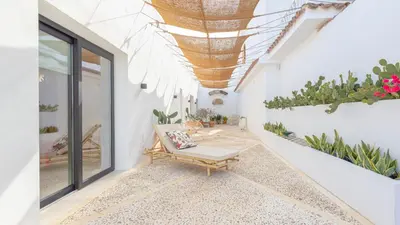 a patio with a bench and potted plants at Casa Chica 1 Sanlúcar de Barrameda. by Ruralidays in Sanlúcar de Barrameda
