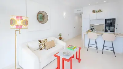 a living room with a white couch and a red table at Casa Chica 1 Sanlúcar de Barrameda. by Ruralidays in Sanlúcar de Barrameda