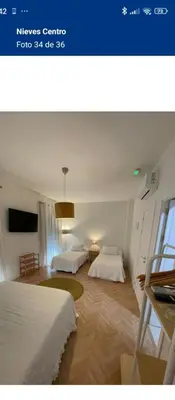 a hotel room with two beds and a tv at Hs Nieves Centro in Chipiona