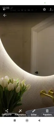 a vase of white flowers in front of a mirror at Hs Nieves Centro in Chipiona