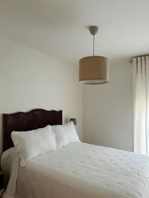a bedroom with a white bed with a white comforter at Hs Nieves Centro in Chipiona
