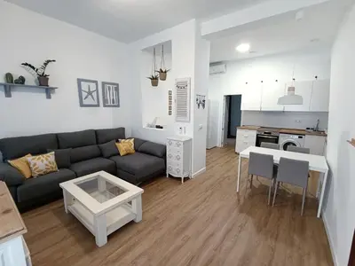 a living room with a couch and a table at Newly renovated flat in the center of Sanlúcar - EARTH SANLUCAR in Sanlúcar de Barrameda