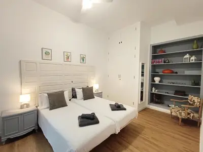 a white bedroom with a large white bed with two pillows at Newly renovated flat in the center of Sanlúcar - EARTH SANLUCAR in Sanlúcar de Barrameda