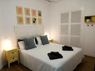 a bedroom with a white bed with pillows on it at Newly renovated flat in the center of Sanlúcar - EARTH SANLUCAR in Sanlúcar de Barrameda
