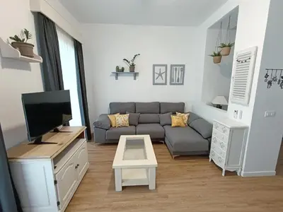 a living room with a couch and a tv at Newly renovated flat in the center of Sanlúcar - EARTH SANLUCAR in Sanlúcar de Barrameda