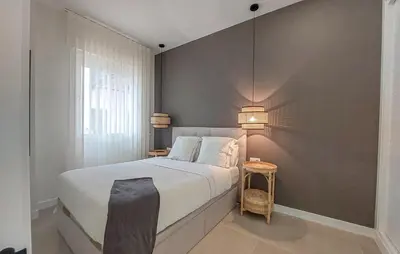 a bedroom with a bed with two lamps on the wall at 1 Bedroom Nice Apartment In Arcos De La Frontera in Arcos de la Frontera